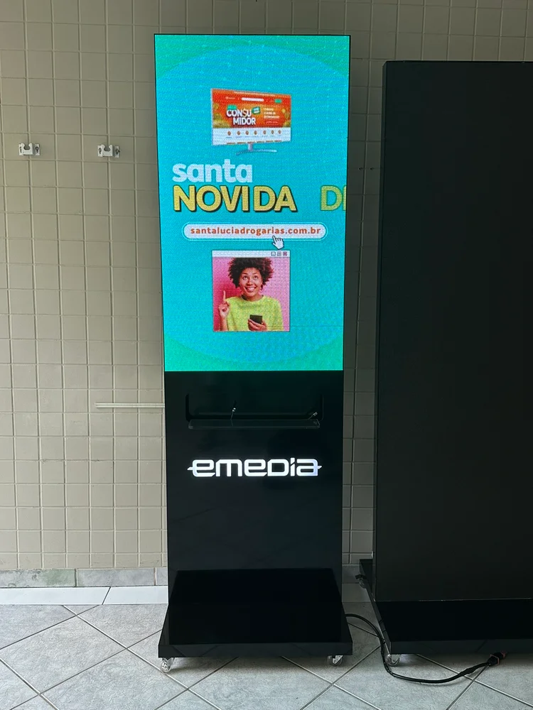 Totem Emedia exibindo anúncio da Santa Lúcia
