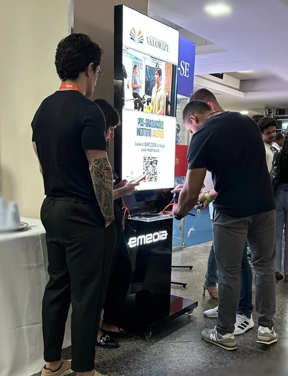 Pessoas utilizando a estação de recarga Emedia em evento