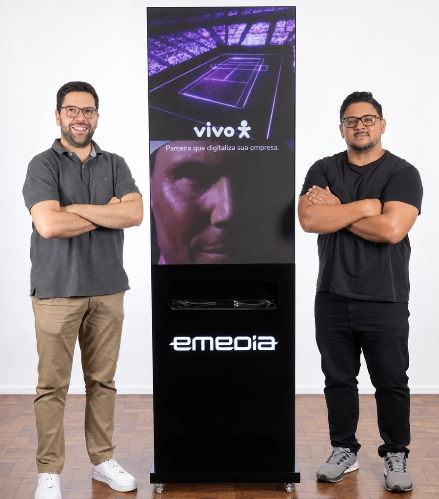 Equipe Emedia ao lado do totem LED com estação de recarga